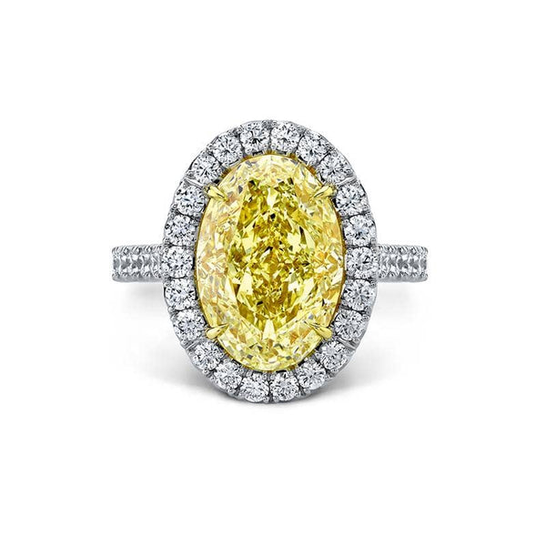Custom made ring featuring a 5.06 carat oval shaped fancy yellow diamond with 1.26 carats total weight in round brilliant cut diamonds set in platinum and 18k yellow gold.