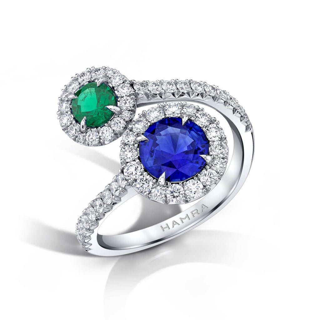 Custom made ring featuring a 1.27 carat round blue sapphire, a .46 carat round emerald and .82 carats total weight in round brilliant cut accent diamonds set in platinum.