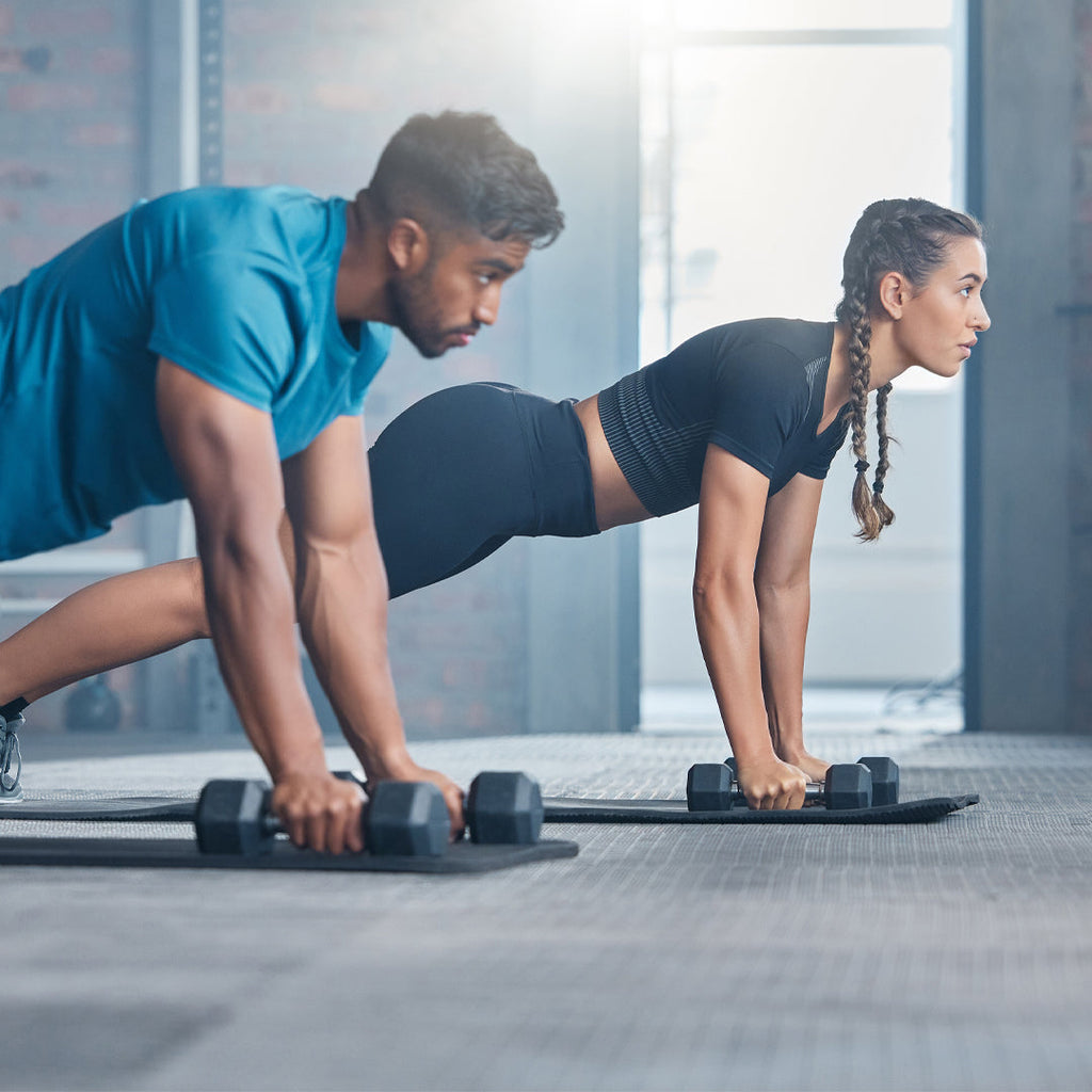 man and woman doing push-ups holding weights.