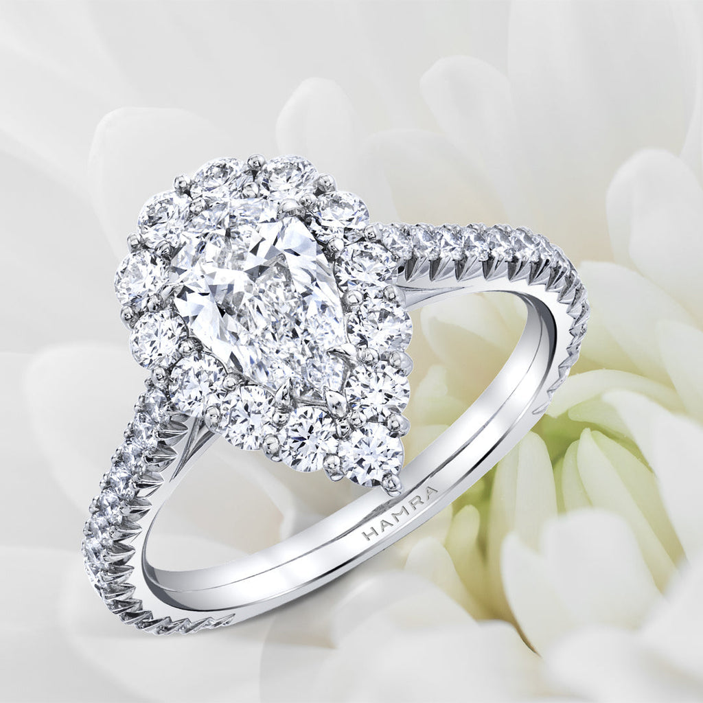 Pear shaped diamond ring sitting in flower.