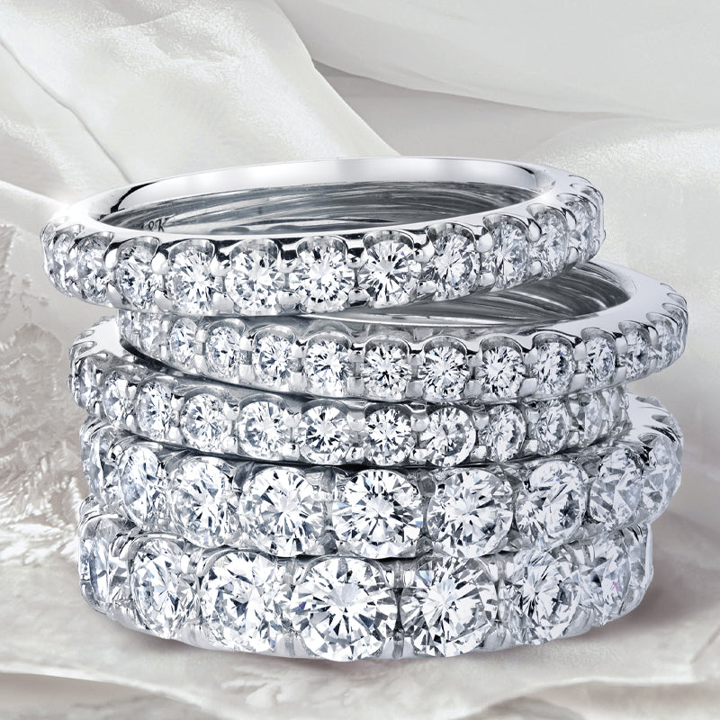Stack of five diamond eternity wedding bands.