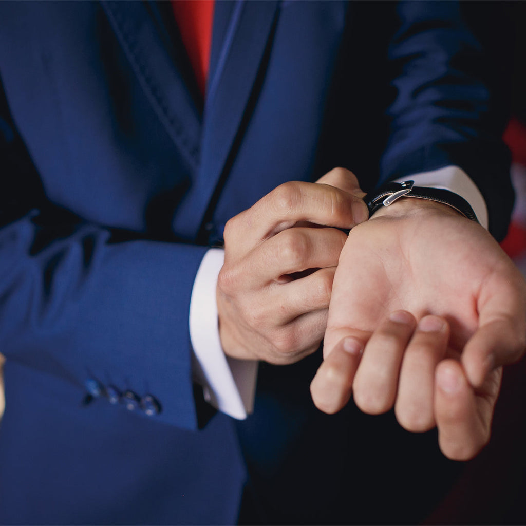 Man in suit adjusting watch