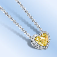 Heart shaped yellow diamond necklace in platinum with diamond halos