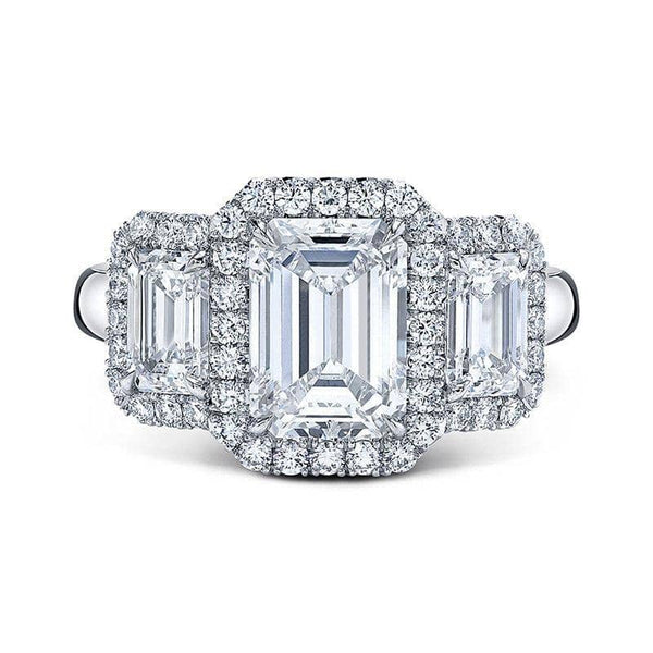 Custom made ring featuring three emerald cut diamonds - 2.00 ct center and 1.18 carats total weight in side diamonds including .43 carats total weight in round brilliant cut accent diamonds set in platinum.