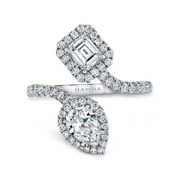 Custom made bypass ring featuring a .65 carat pear shaped diamond, a .45 carat emerald cut diamond and .57 carats total in round brilliant cut diamond accents set in platinum.