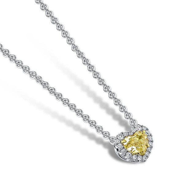 Custom made necklace featuring a 1.01 carat heart shaped fancy yellow diamond center stone with a white diamond halo consisting of .15 carats total weight in round brilliant cut diamonds set in platinum and 18k yellow gold.