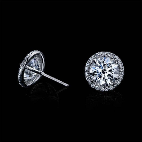 Hand crafted stud earrings featuring 4.05 carats total weight in round brilliant cut diamond centers with .37 carats total weight in accent diamonds set in 18k white gold.